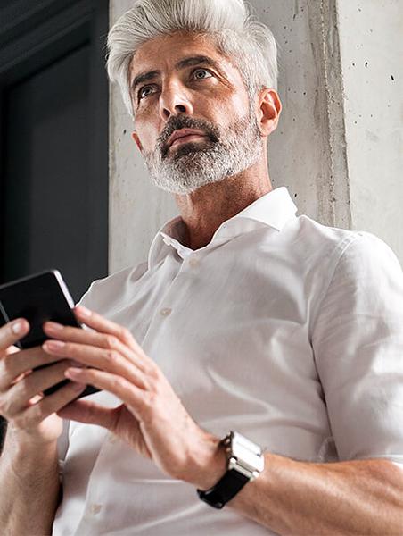 Older gentleman checking his phone for targeted direct mail solutions for law firms